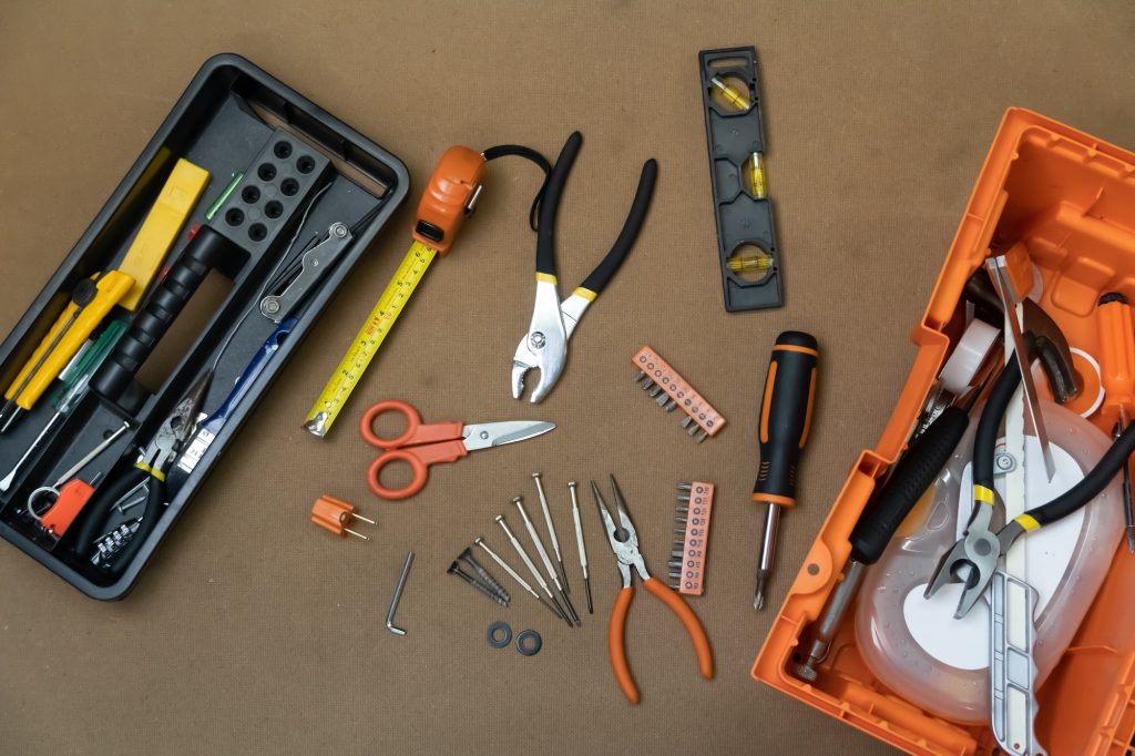 Collection of tools to be used to fix a meter box including long nose pliers