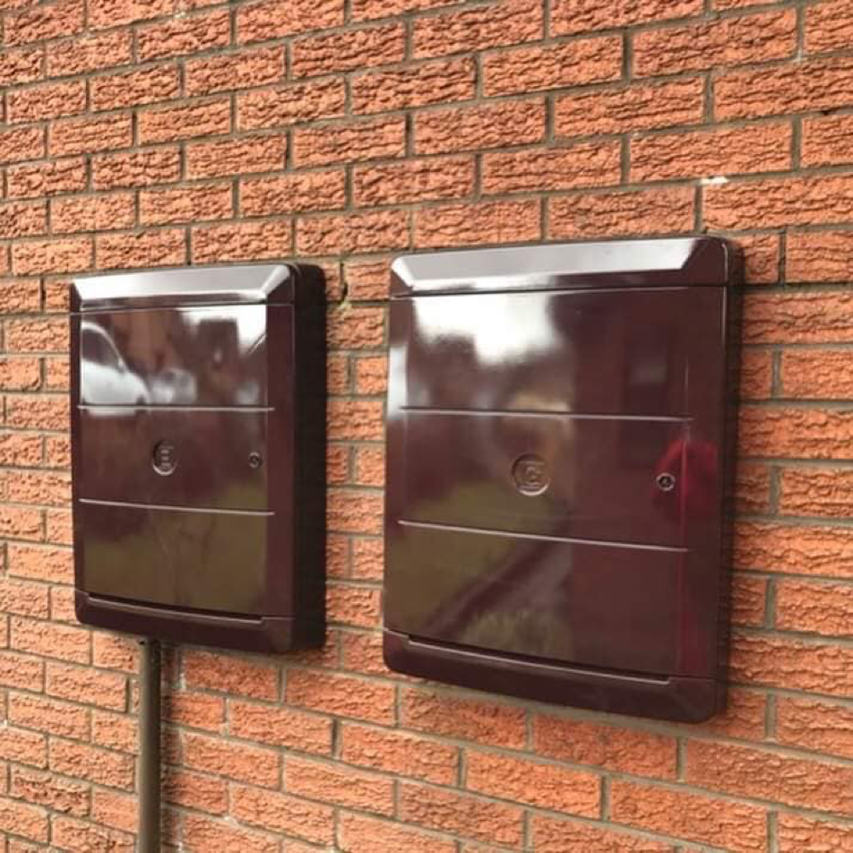 Brown meter box overbox on a brick wall